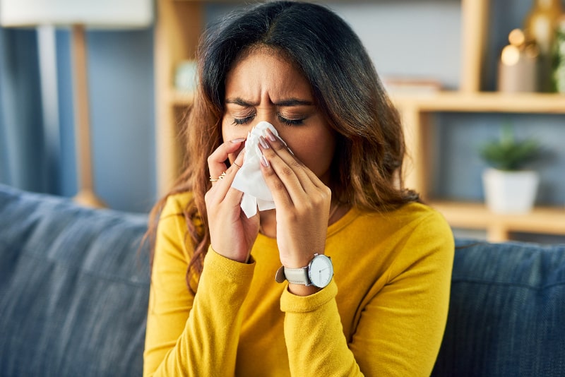woman sneezing because her home has poor indoor air quality